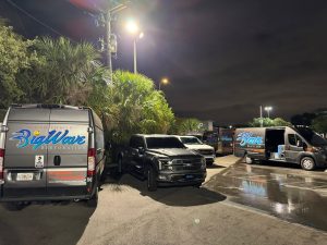 Big Wave Restoration service vehicles parked together at night
