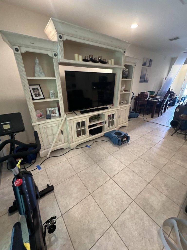 Air movers drying a living room during a Big Wave Restoration project