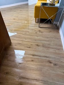 Standing water on wood-look flooring from a Big Wave Restoration project
